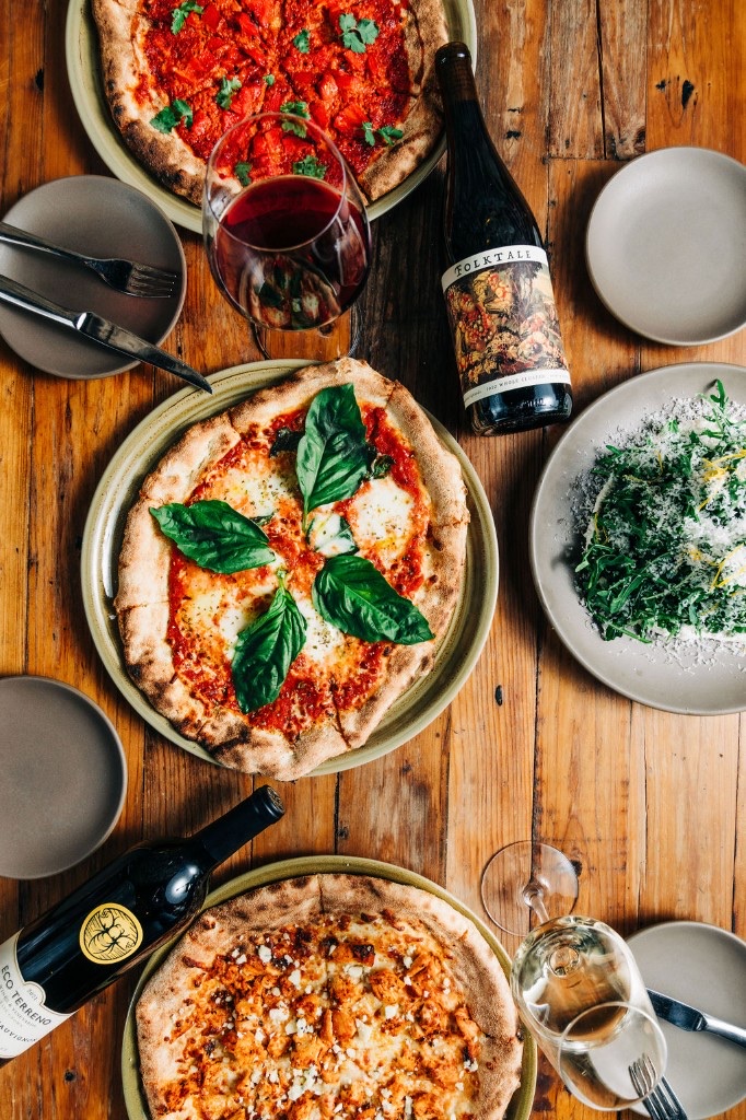 Wood-fired pizza party spread with wine at Stone House private event catering