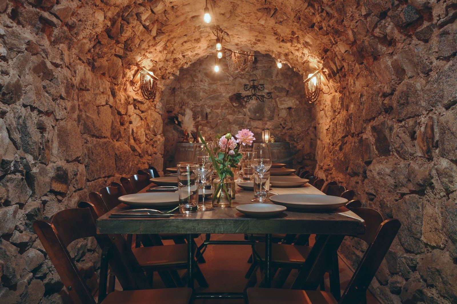The Cavern at Stone House Nevada City — underground stone-walled event space with candlelit dinner setup for an intimate private gathering