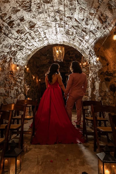 Wedding couple under the historic stone arches of The Cavern at Stone House Nevada City — candlelit ceremony in 1800s underground space