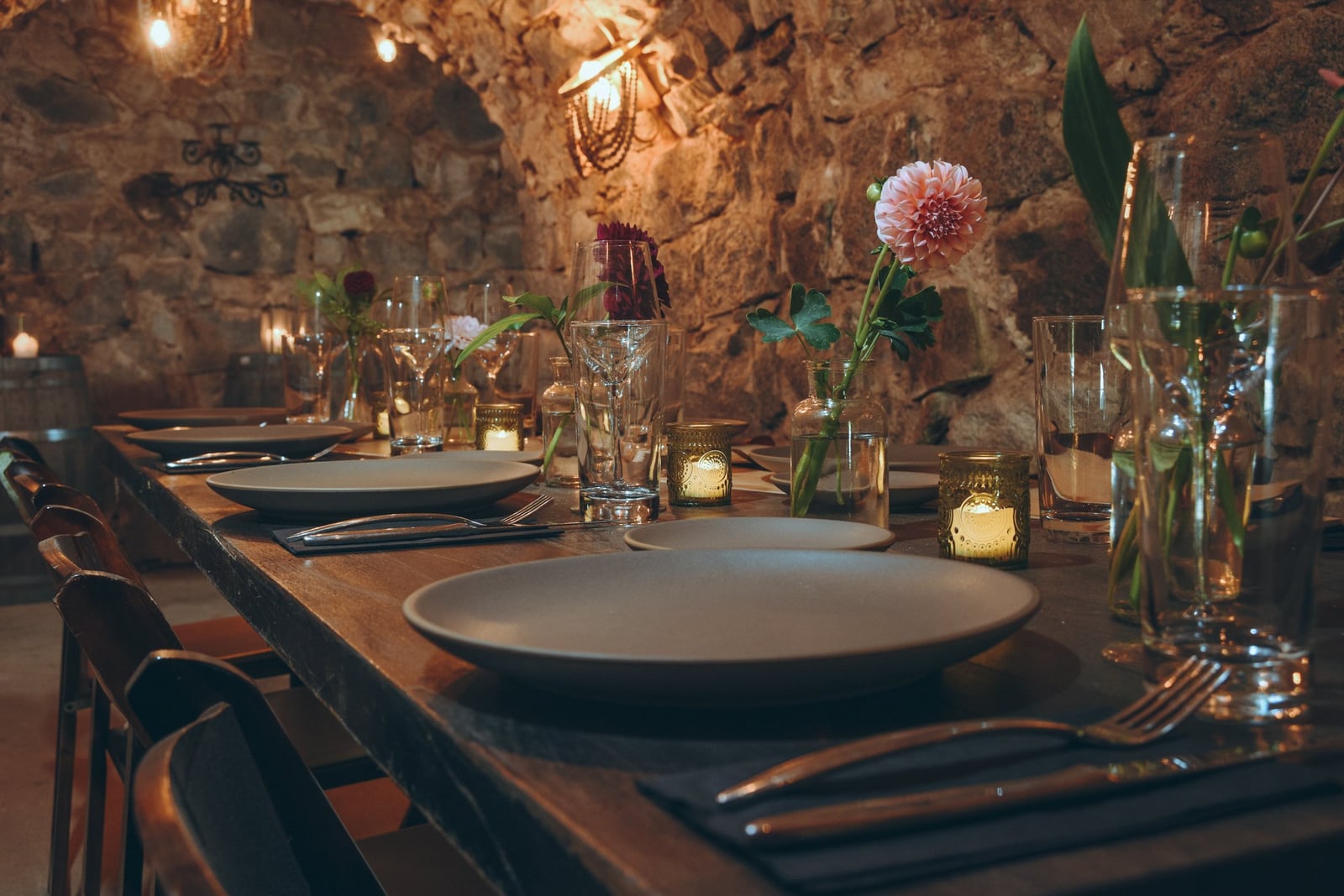 Wedding service in The Cavern at Stone House Nevada City — candlelit underground stone arches set for an intimate ceremony