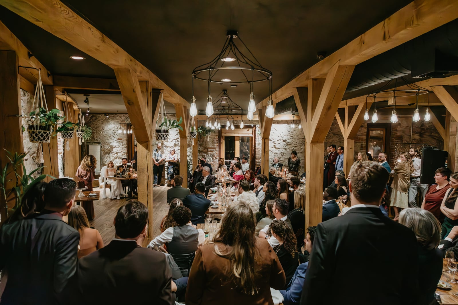 Wedding toast in The Great Hall at Stone House Nevada City — original 1857 stone walls and event lighting