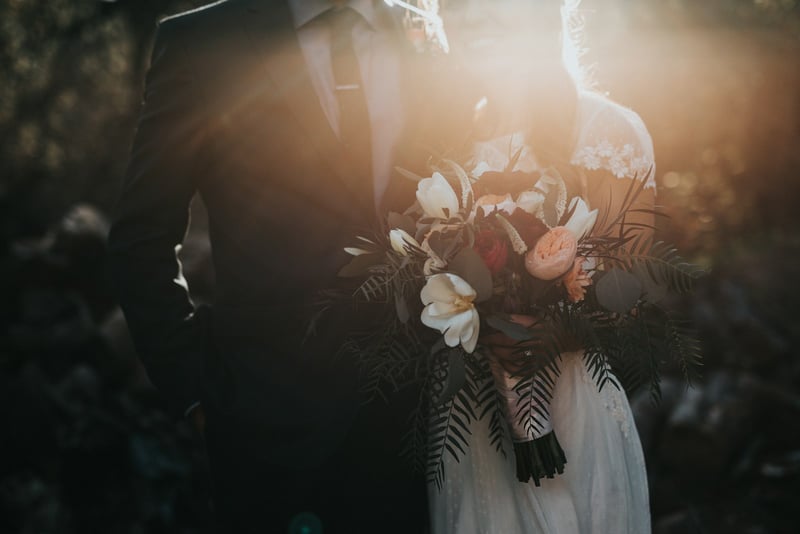 Outdoor wedding ceremony setup with chairs and floral arch in a garden setting