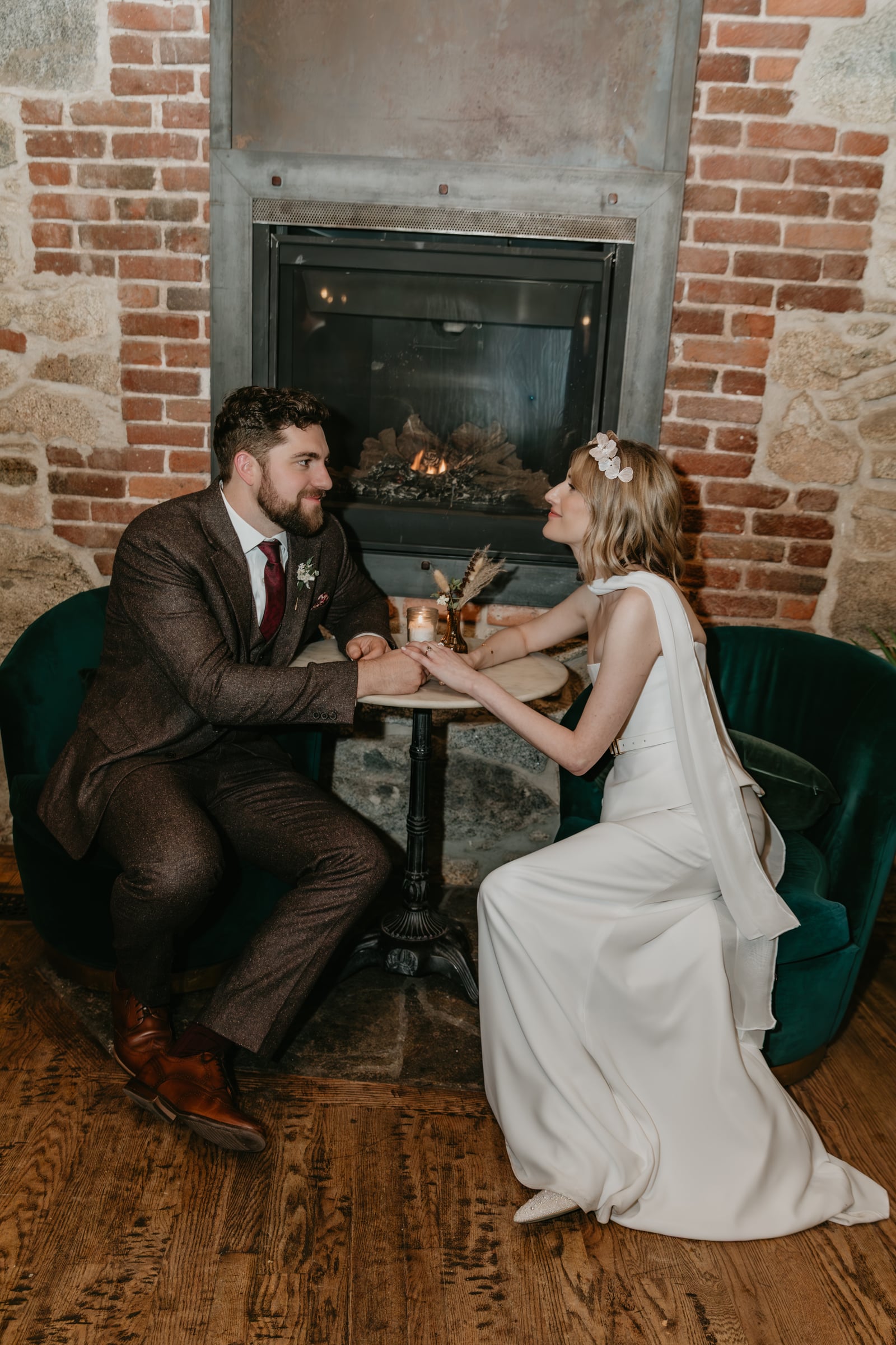 Wedding couple by the fireplace in The Parlor at Stone House Nevada City — first-floor cocktail-hour space
