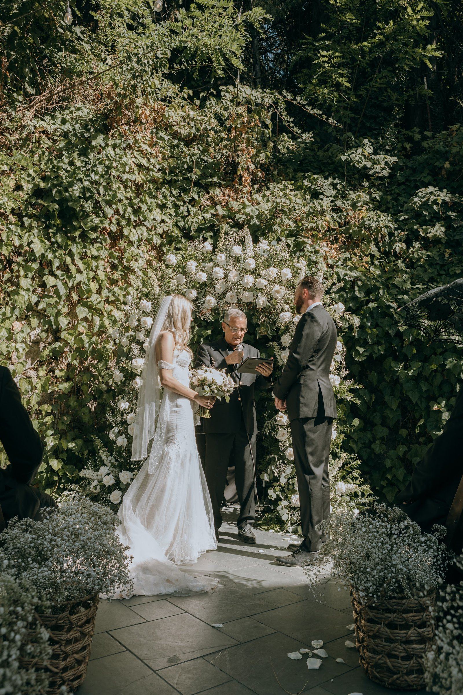 Wedding ceremony in progress at Stone House Nevada City — couple at the altar inside the historic Great Hall, guests seated on either side